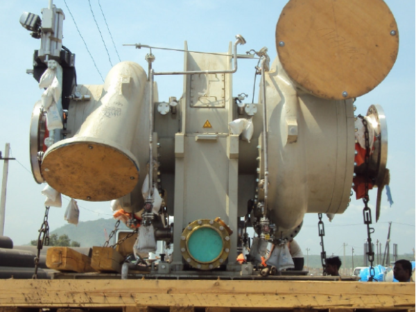 Un gran conjunto de válvulas industriales con múltiples tuberías y componentes montado sobre una plataforma de madera en un barco.